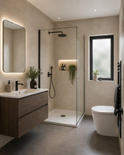 Load image into Gallery viewer, Modern bathroom interior with a glass shower enclosure, floating wood vanity, white toilet, and textured beige walls and floor tiles.