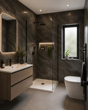Load image into Gallery viewer, Modern bathroom interior with a walk-in shower enclosure, floating wood vanity with white basin, white toilet, dark stone walls, and a window with black frame.